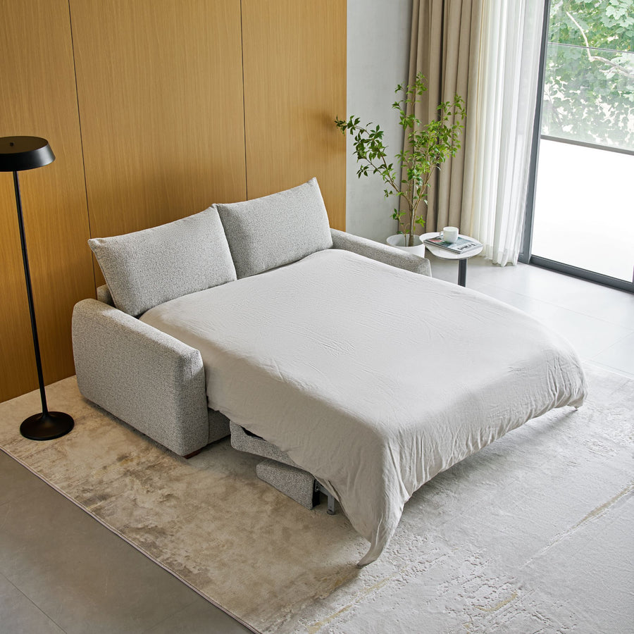 Nadia Sofa Bed opened as a bed with white bedding, angle view