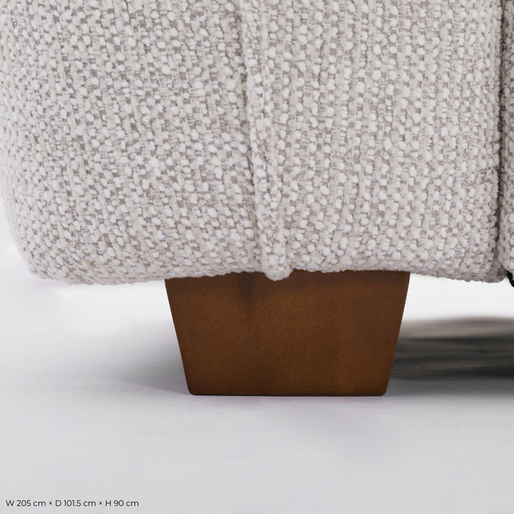 Close-up of the Franka Sofa Bed's light grey woven upholstery and tapered timber foot