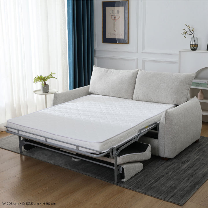 Franka Sofa Bed folded out into a double bed with the mattress extended, styled in a living room, angled view