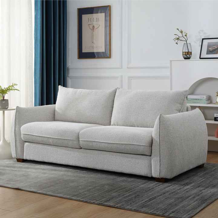 Franka Sofa Bed as a three-seat sofa in light grey woven fabric, angled view in a styled living room