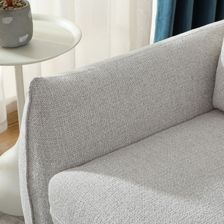 Close-up of the Franka Sofa Bed's arm and backrest, styled beside a white side table