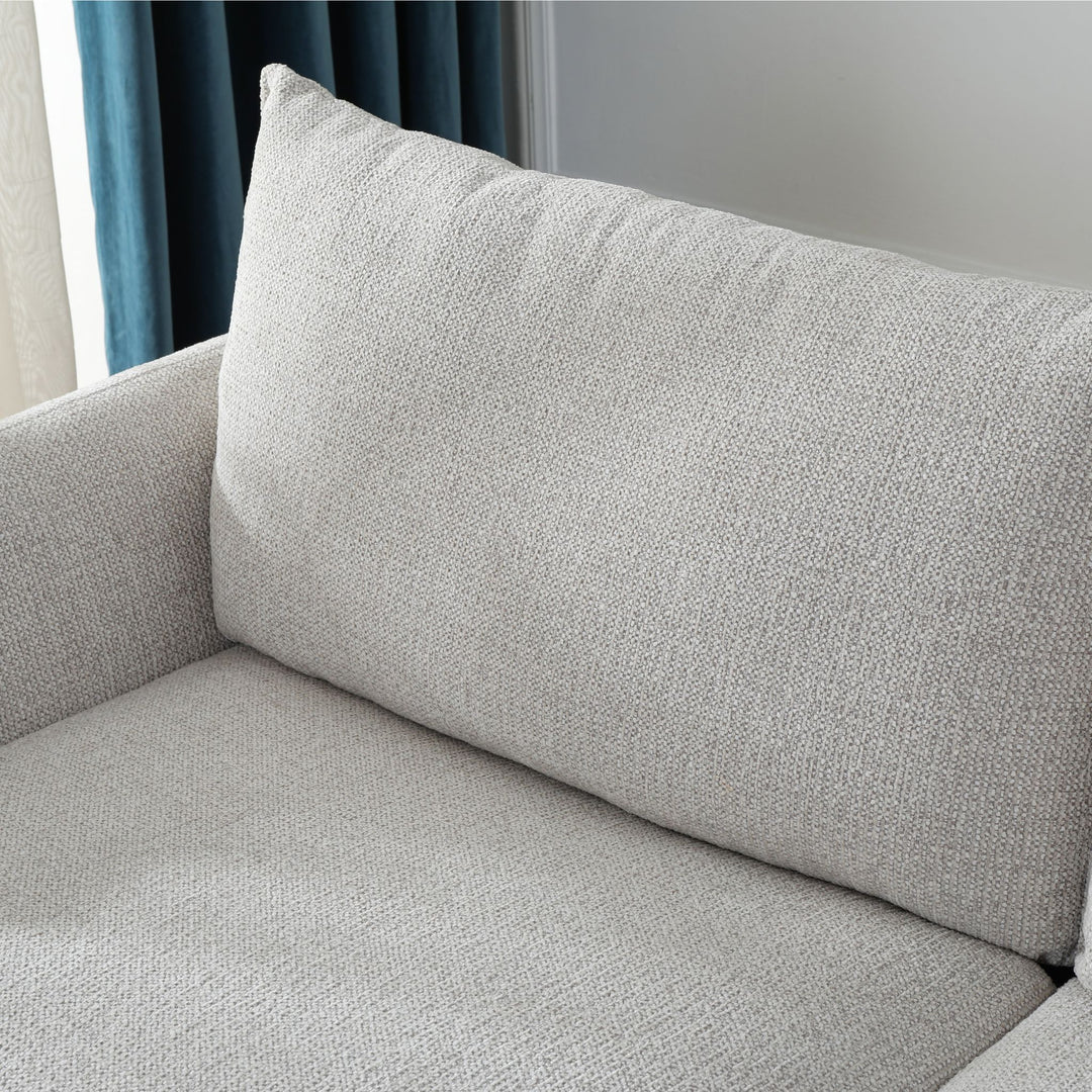 Close-up of the Franka Sofa Bed's plump back cushion and light grey woven fabric seat