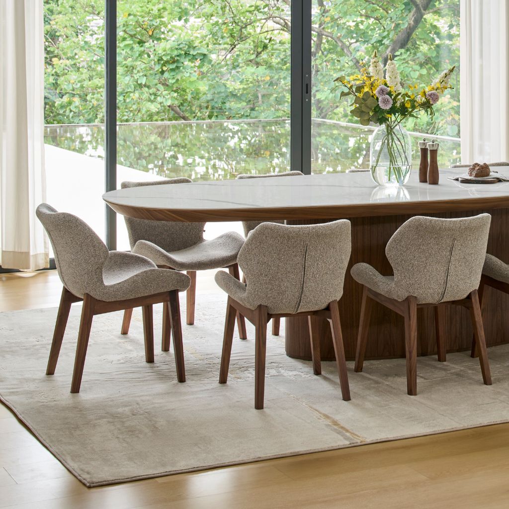 Viva Walnut Dining Chairs around the Ava Oval Dining Table in walnut