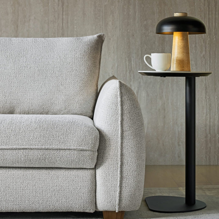 Ava Side Table with a Bianco ceramic top and satin black pedestal beside a sofa