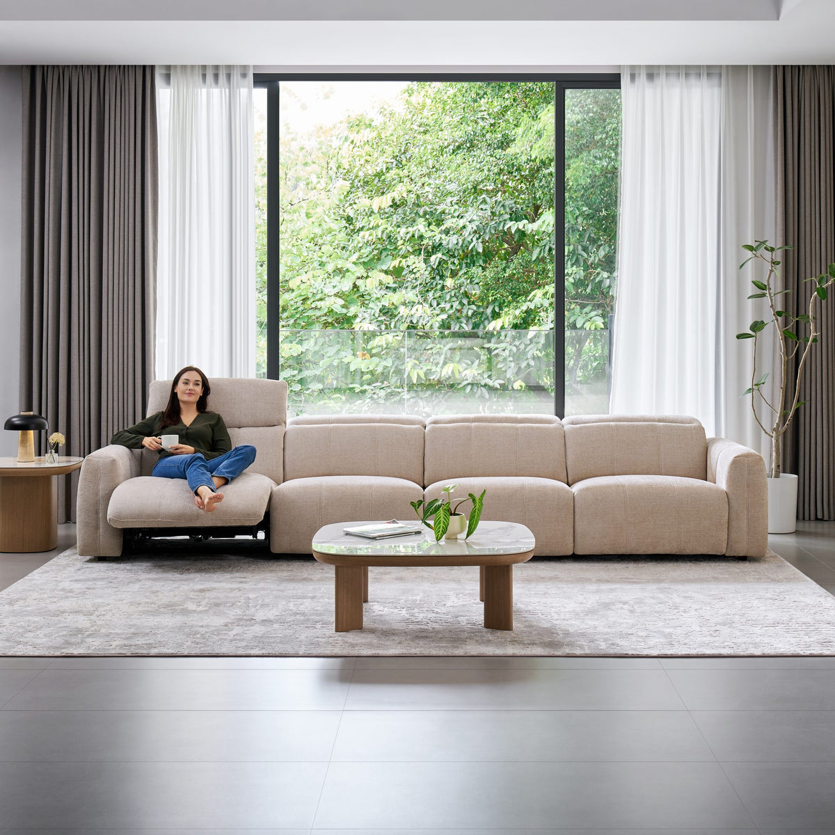 Woman relaxing on the Bailey 4 Seat Sofa with the end seat reclined