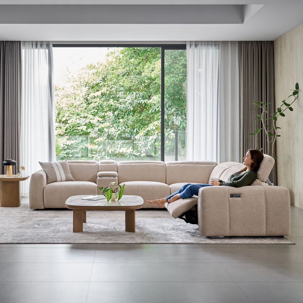 Woman reclining at the end of the Bailey Corner Sofa in beige fabric