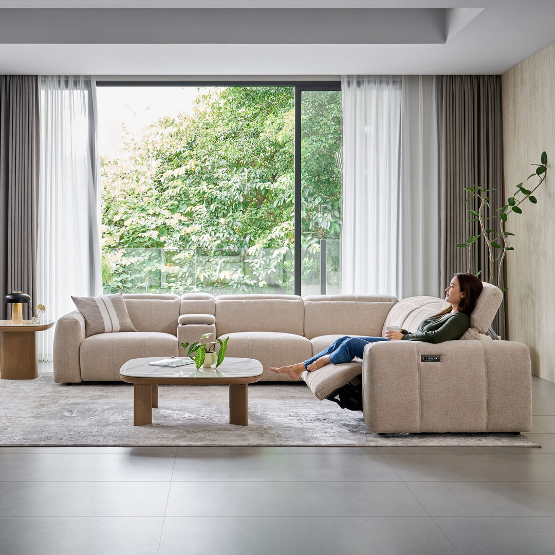 Woman reclining at the end of the Bailey Corner Sofa in beige fabric