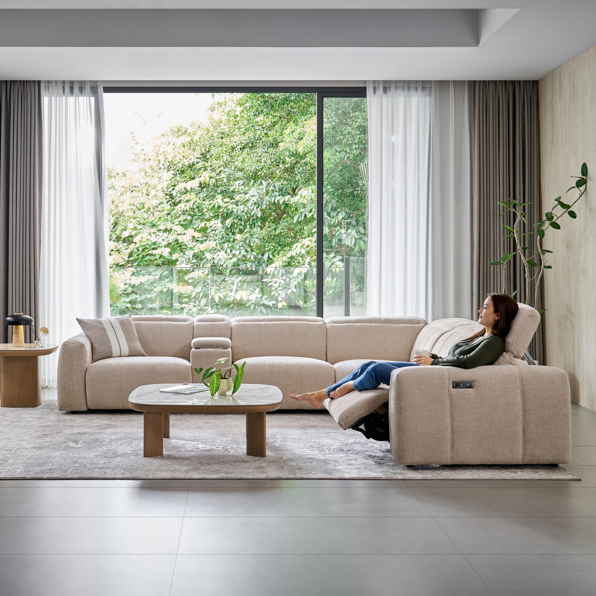 Woman reclining at the end of the Bailey Corner Sofa in beige fabric