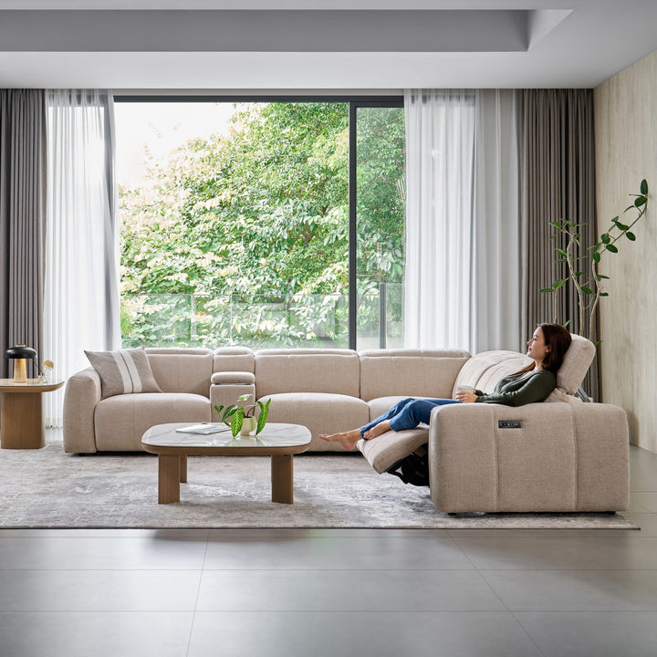 Woman reclining at the end of the Bailey Corner Sofa in beige fabric