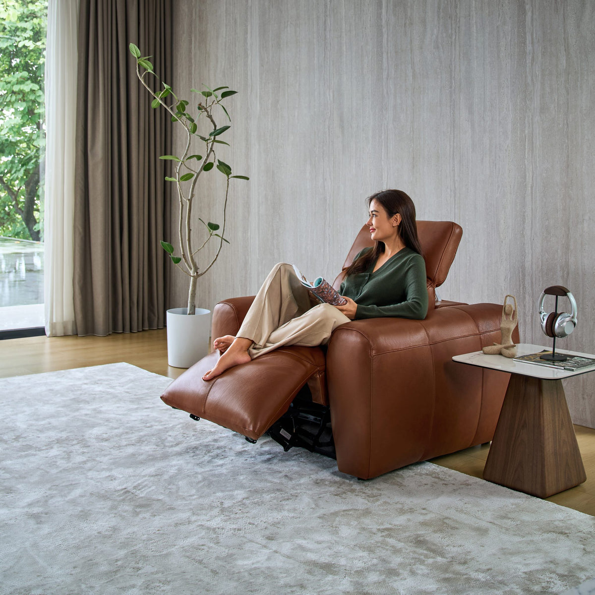 Woman reading in a reclined Cambridge armchair in tan leather