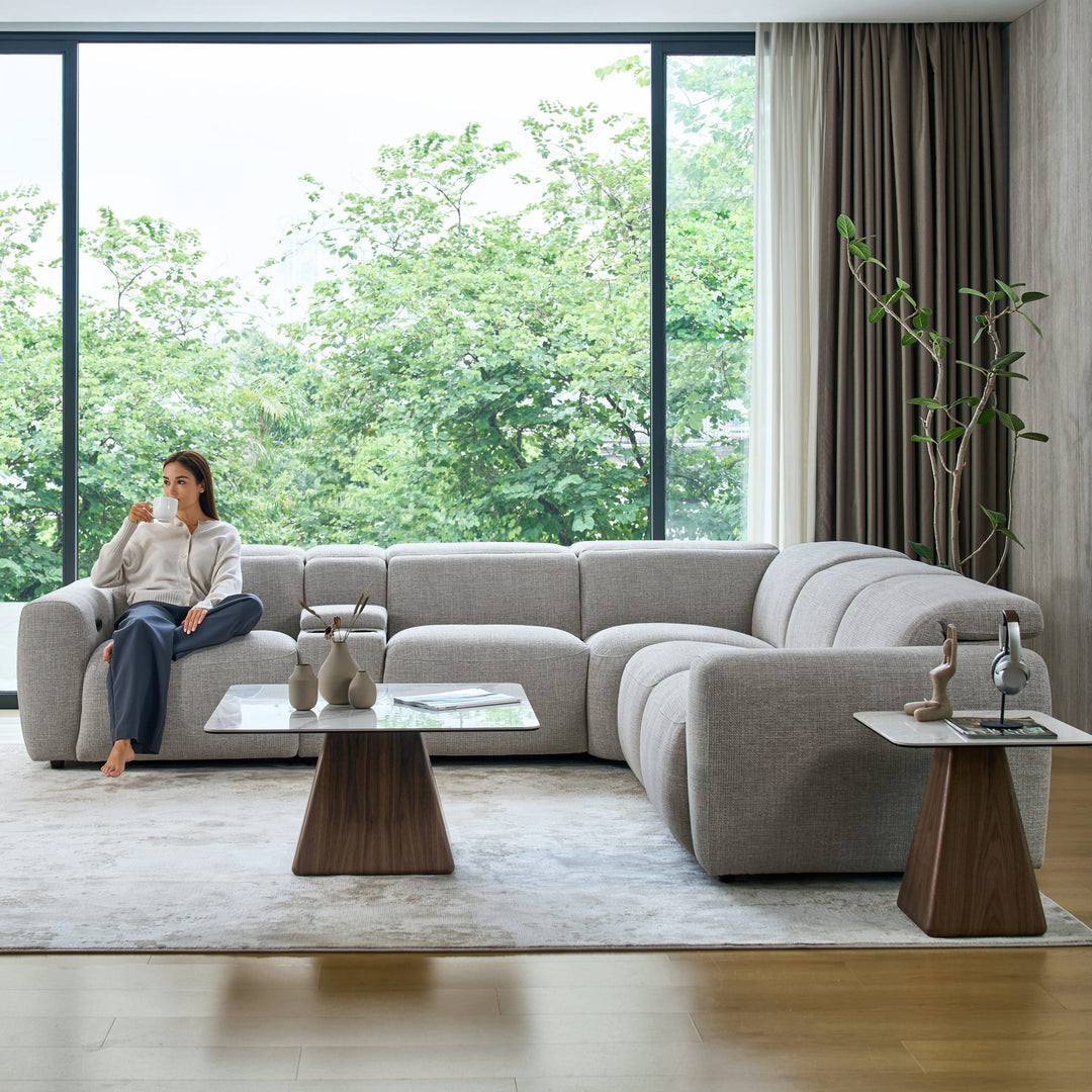 Cambridge corner recliner sofa in light grey fabric, front view, with a woman seated