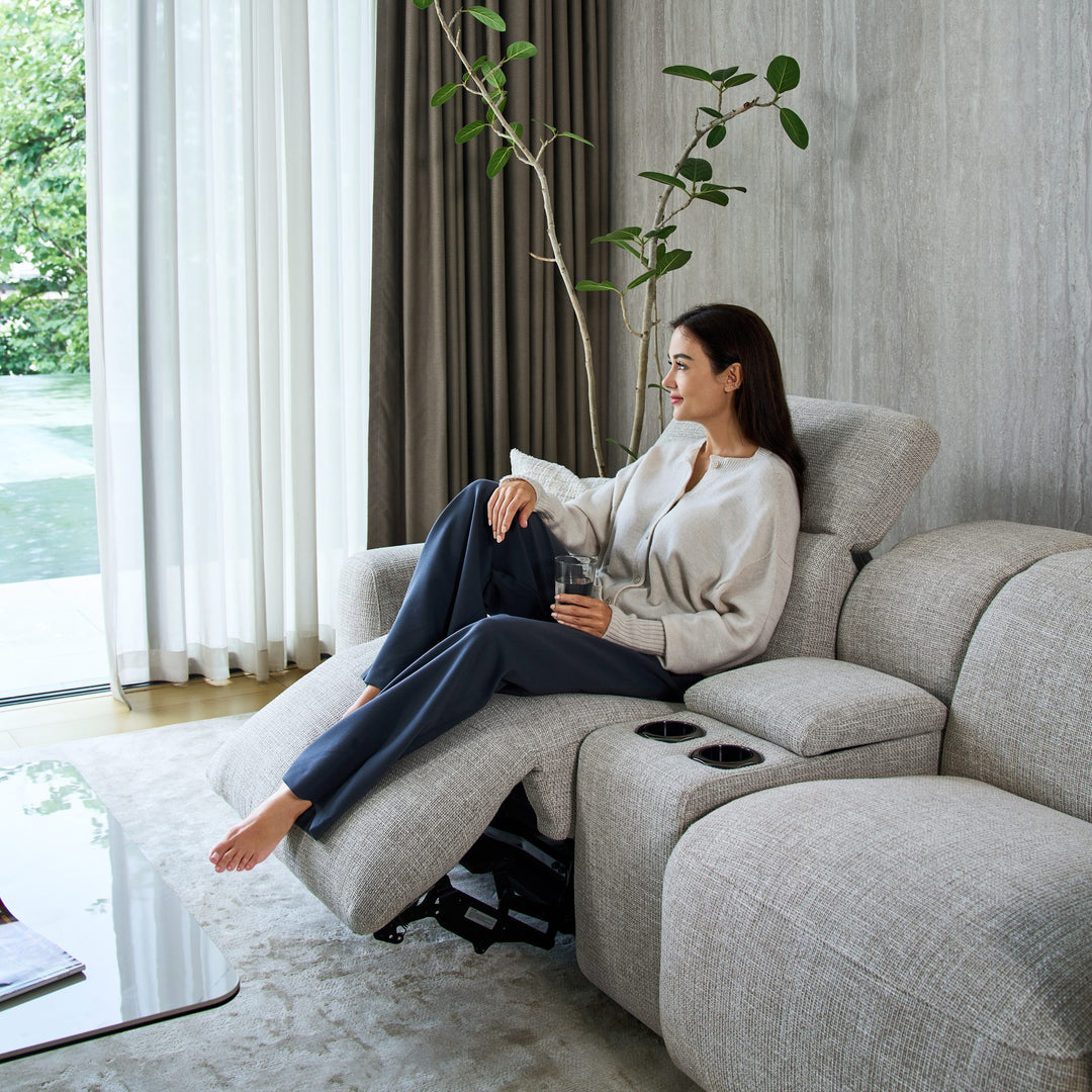 Cambridge media console with cup holders between two reclining seats in light grey fabric