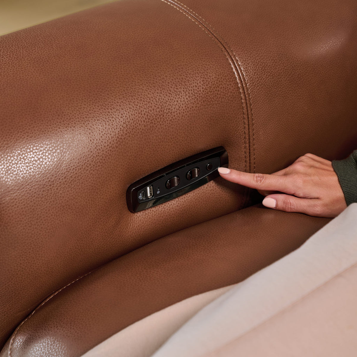 Recline, headrest and USB controls on the side of a Cambridge seat in tan leather