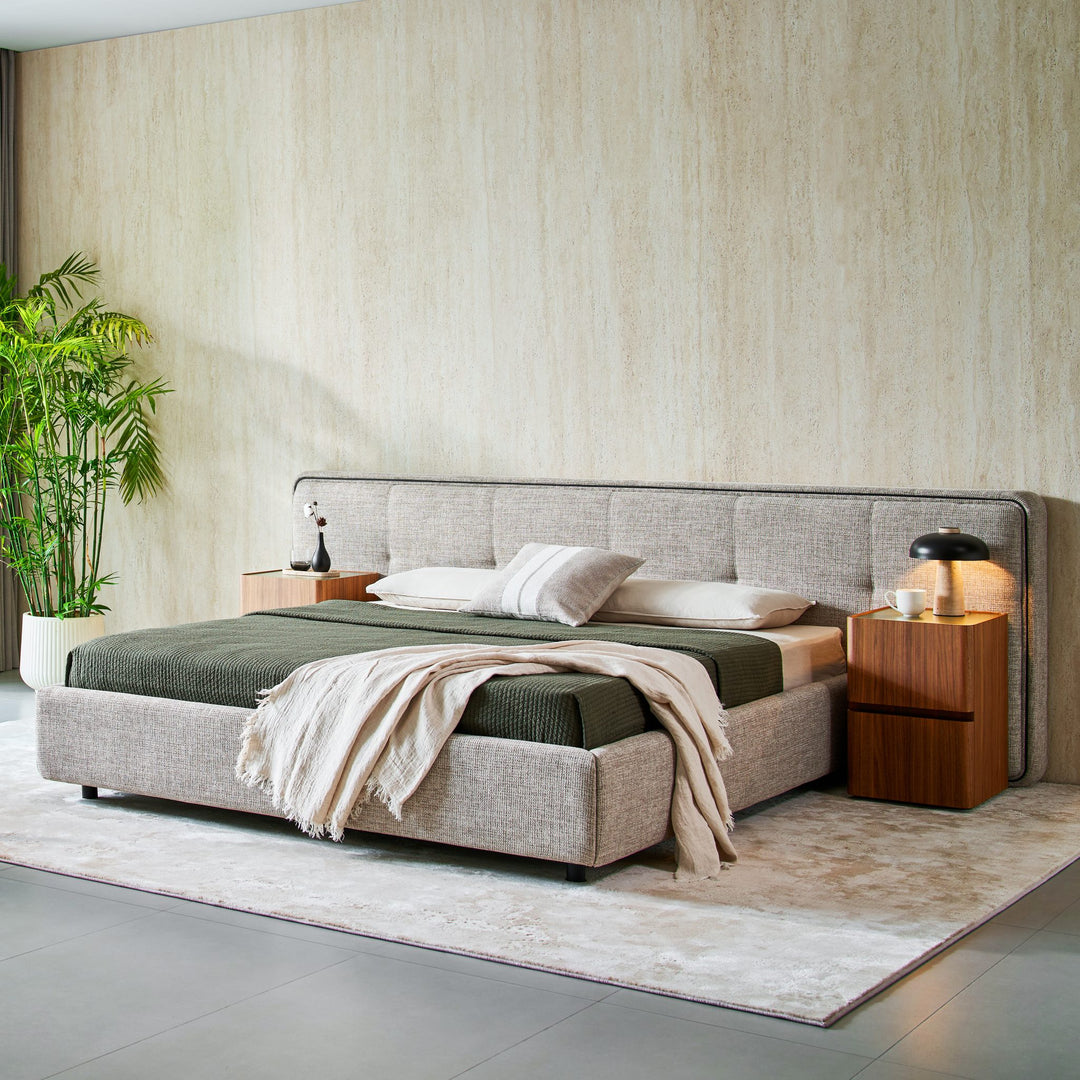 Clara Bed in light grey fabric styled in a bedroom with walnut bedside tables