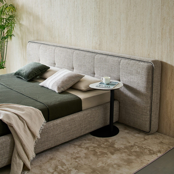 Side view of the Clara Bed headboard with its panelled fabric and slim black trim