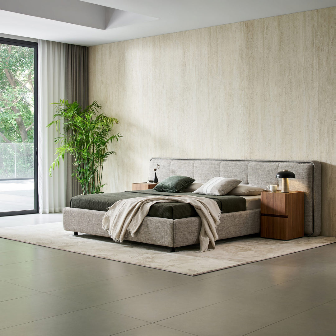 Clara Bed in a large bedroom beside floor-to-ceiling windows