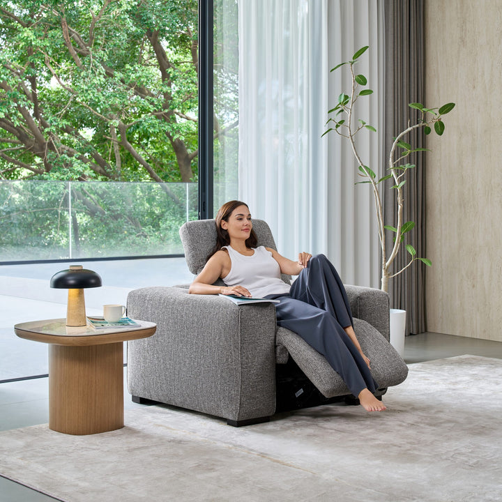 Woman relaxing in the Jeddah recliner armchair with the footrest and headrest raised