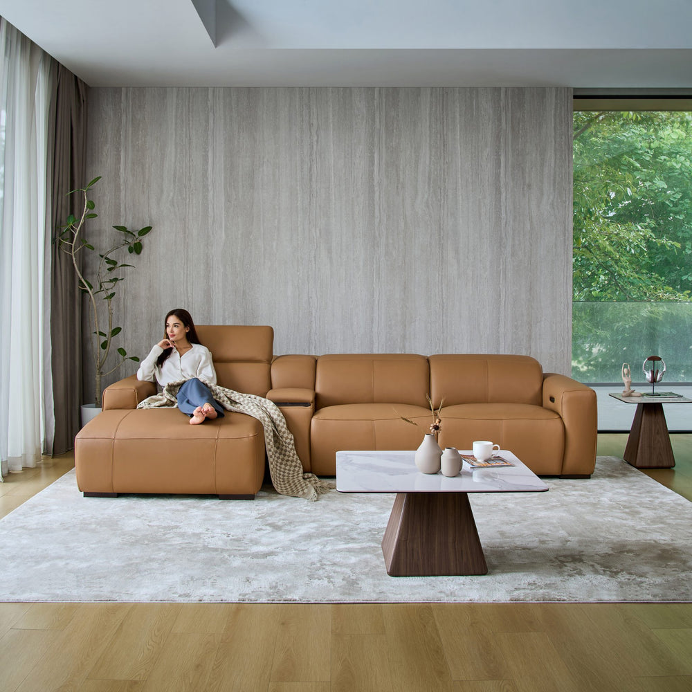 Woman relaxing on the chaise of the Jeddah sofa in tan leather