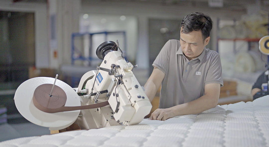 Taping a mattress edge in the Gainsville mattress workshop