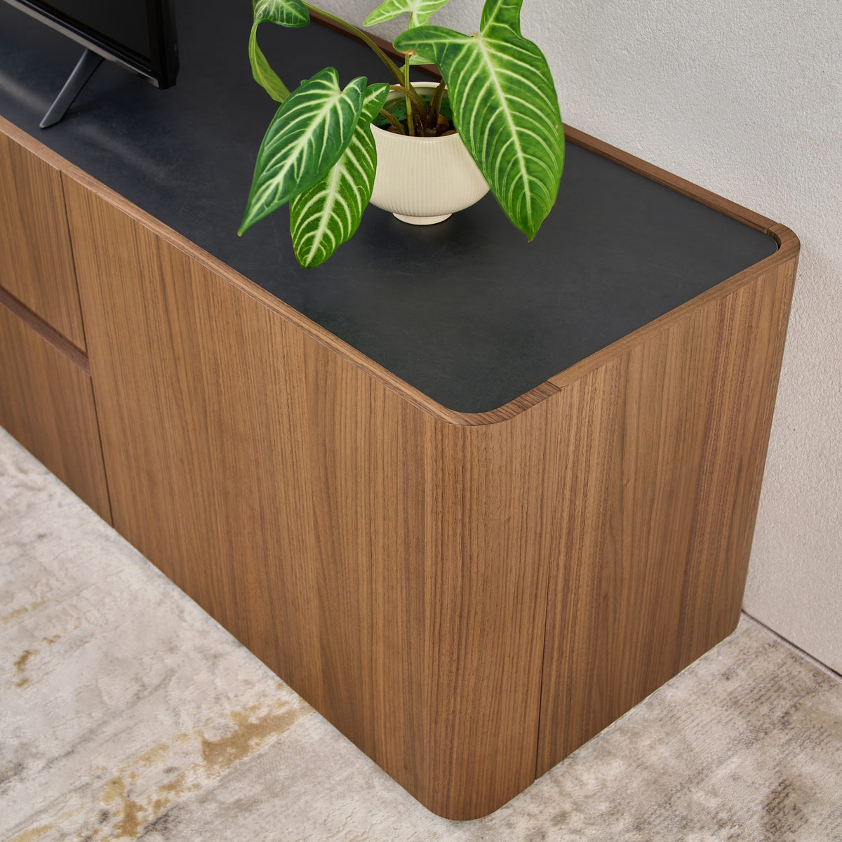 Close-up of the Persia TV Unit Vixon ceramic stone top and rounded walnut corner