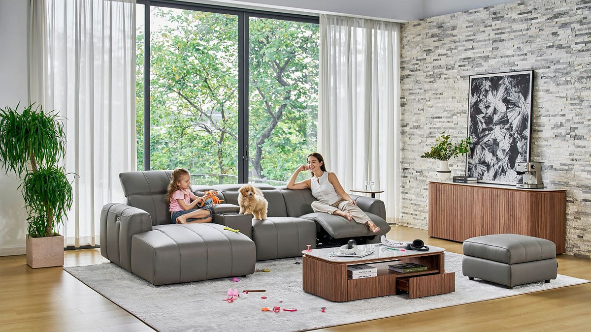 Girl, mother and their dog on the Bailey Chaise Sofa in grey leather, with a stone-top coffee table and storage footstool